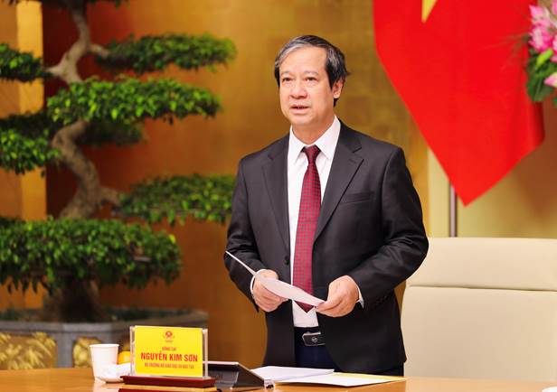 A person in a suit holding a piece of paper Description automatically generated