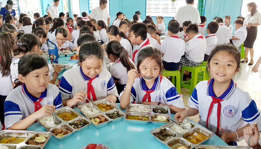 A group of children eating in a classroom  Description automatically generated